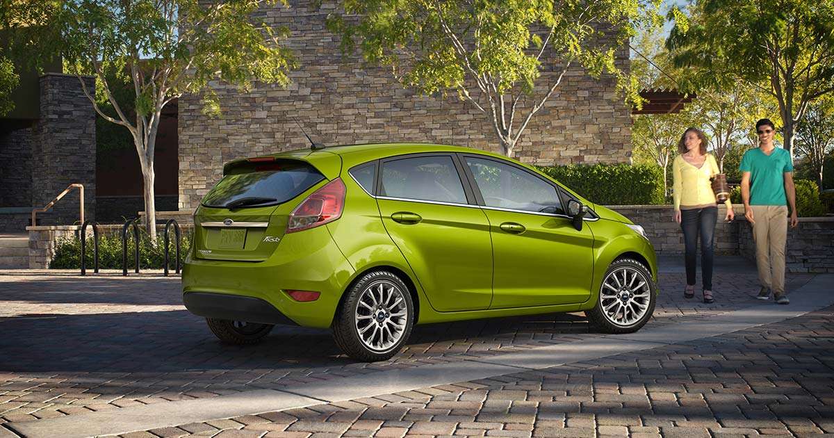 Green Ford Fucus four-door with alloy wheels in shopping area