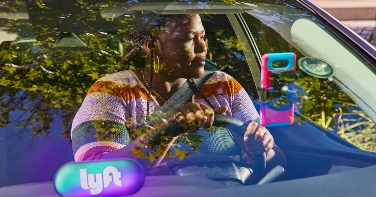 Woman driving her car with Lyft sign on the dash