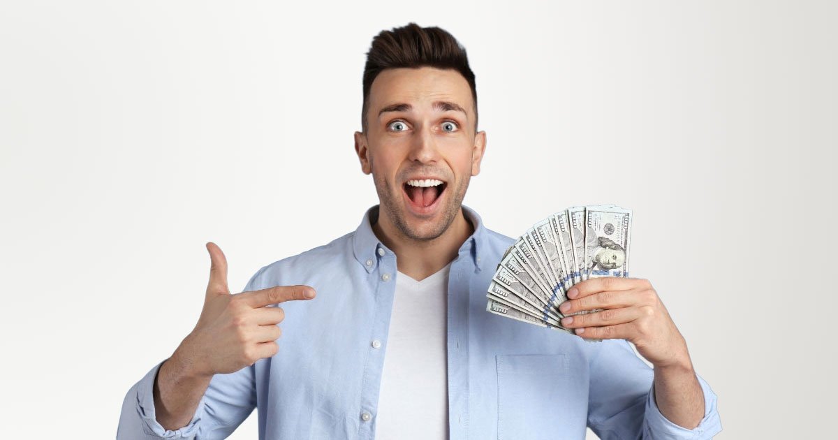 White middle-aged man wearing unbuttoned dress shirt with white undershirt holding stack of cash with white background