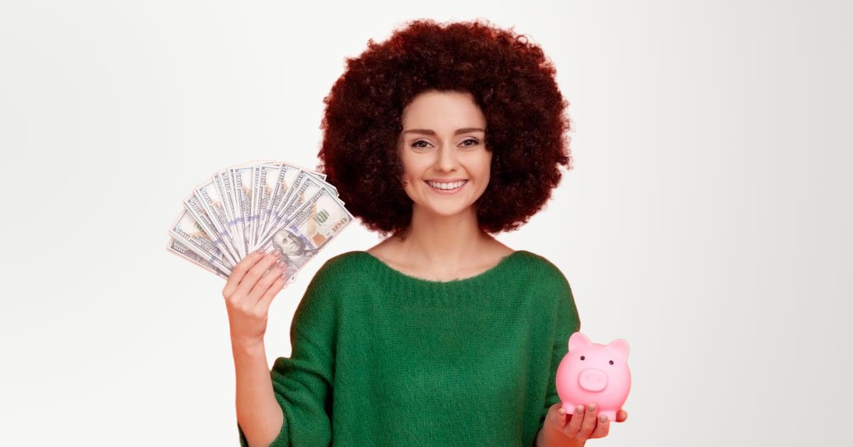 White woman with perm hairdo holding fanned out 100s in right hand and pink piggy bank in left wearing green sweater with orange backdrop