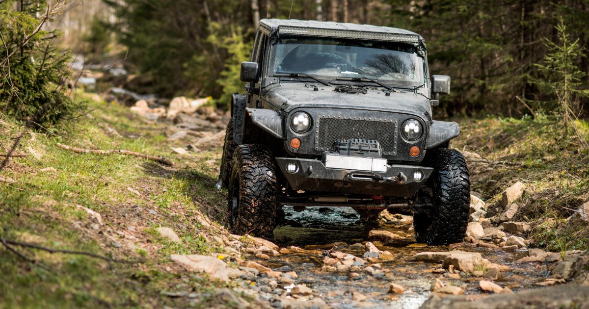 Jeep romping through the woods on off-road course