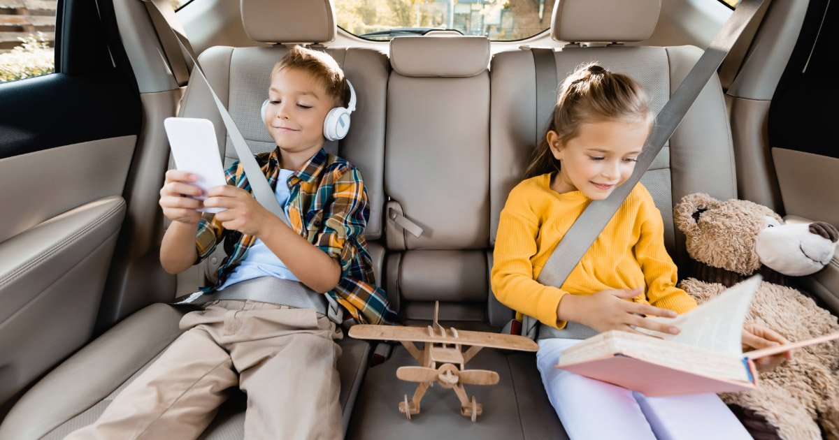 Two kids buckled into their seats in back of SUV